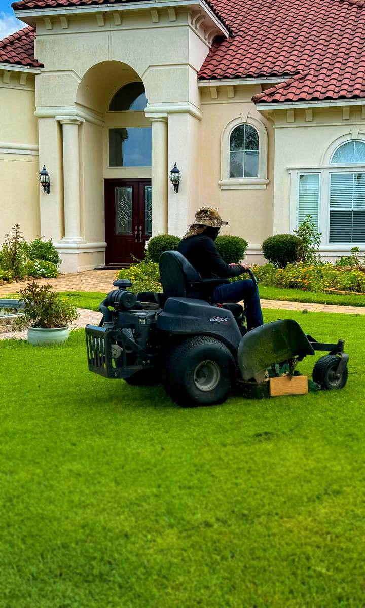 All Special crew member mowing the front lawn of a Katy home